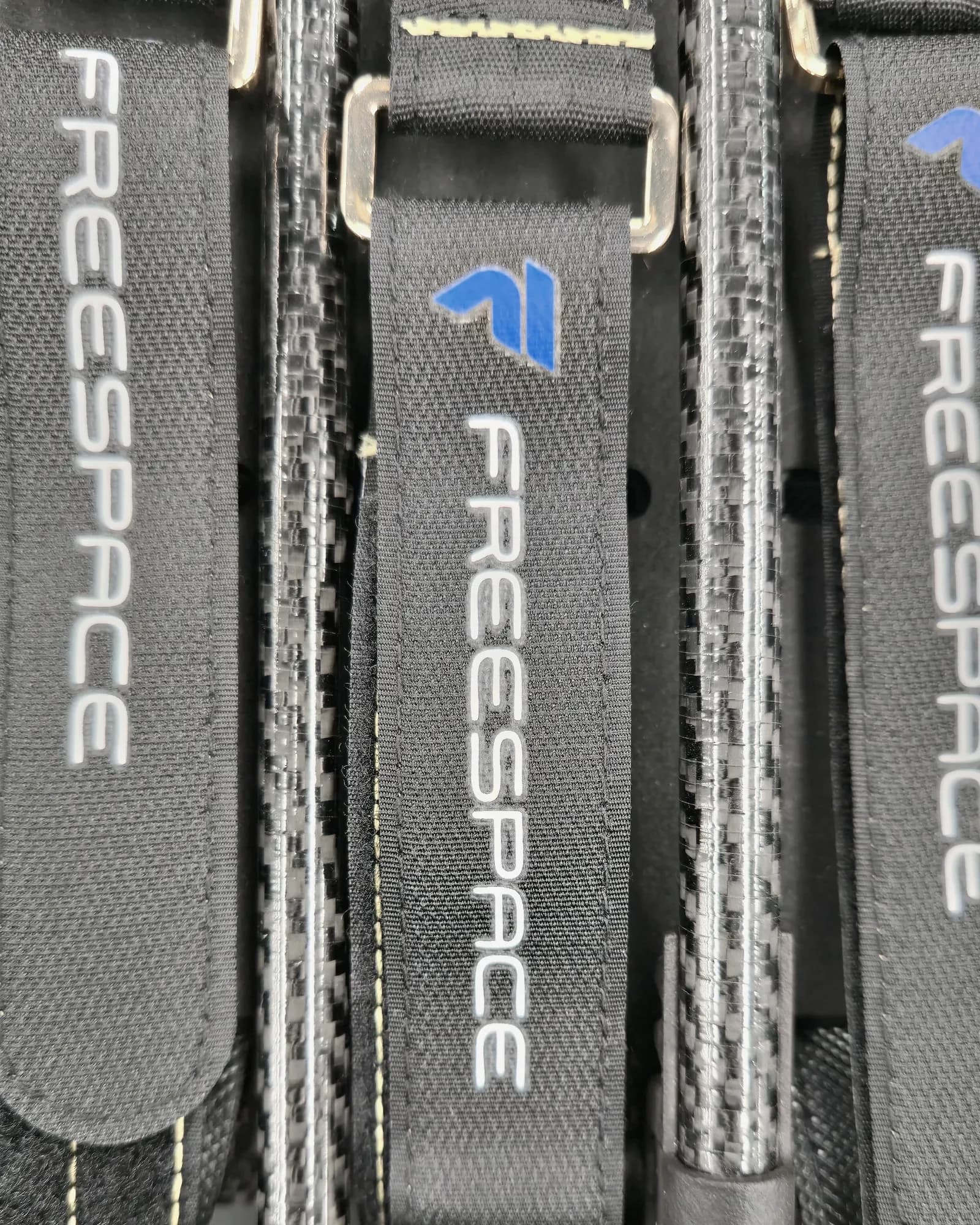 Callisto battery straps embroidered FREESPACE, buckled over the carbon fibre frame
