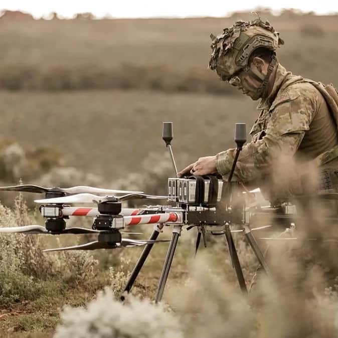 An Australian soldier in camouflage preparing a Callisto in low outback scrub