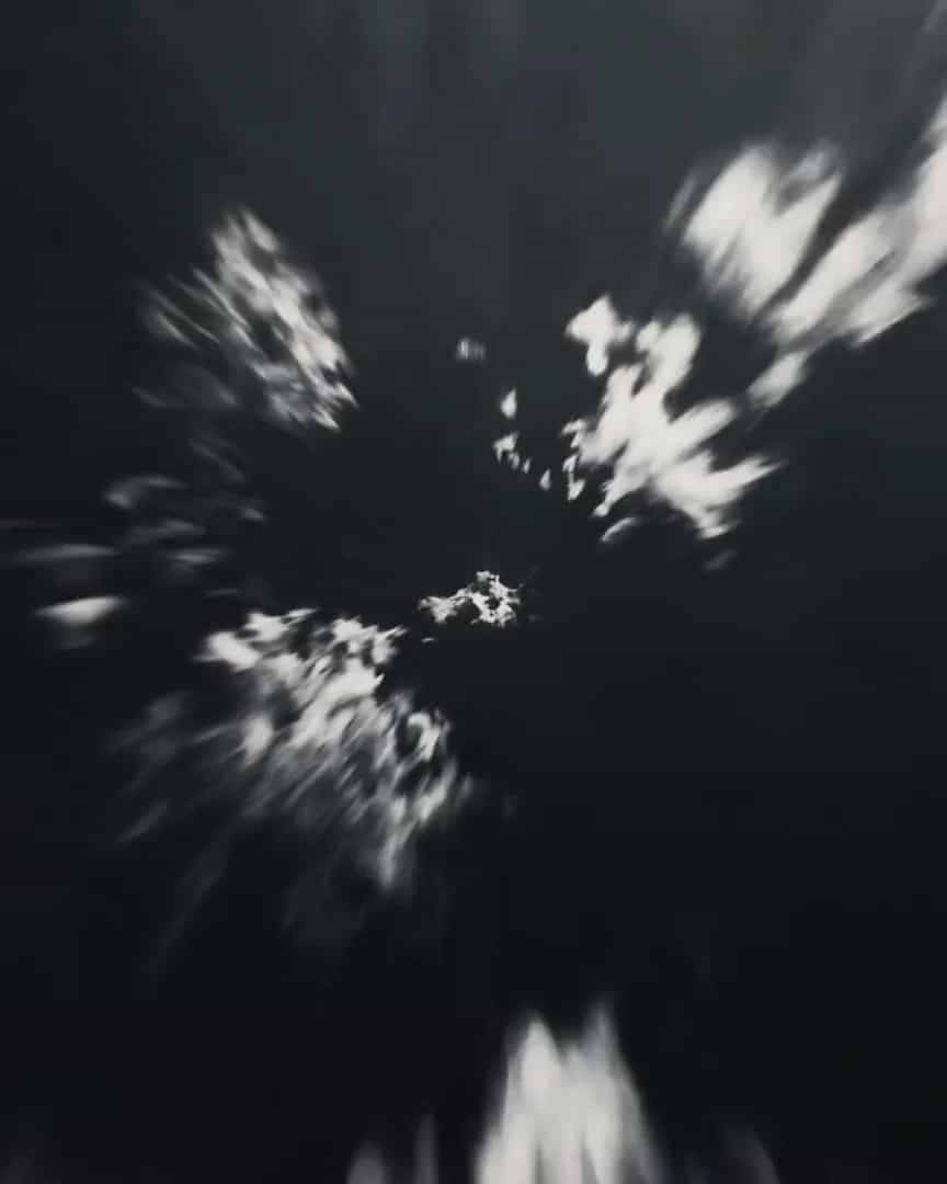 Flying fast through cloud in black and white, the cloud streaking past toward the frame's edges