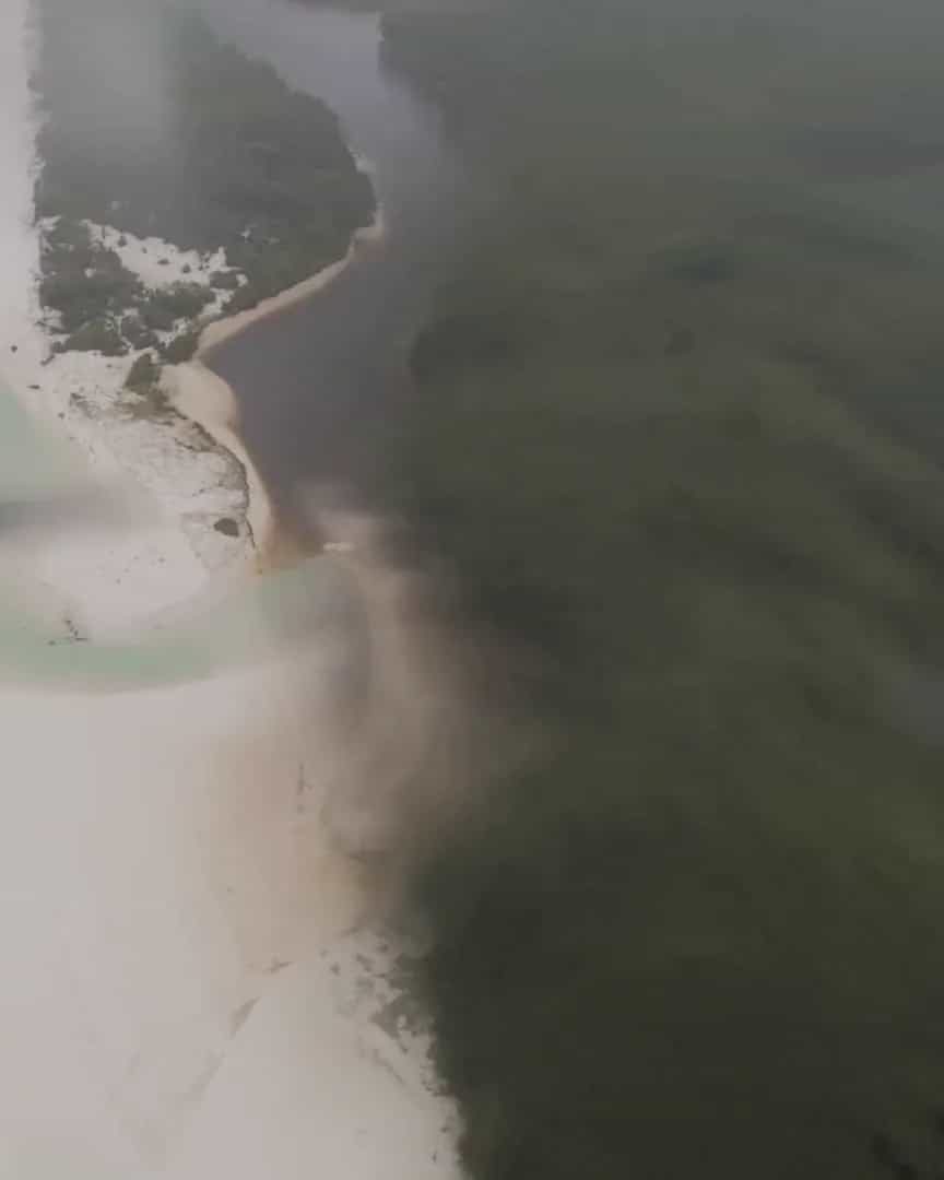 Flying low over a white beach and a river mouth, then hands fitting a RIEGL LiDAR beneath a Callisto